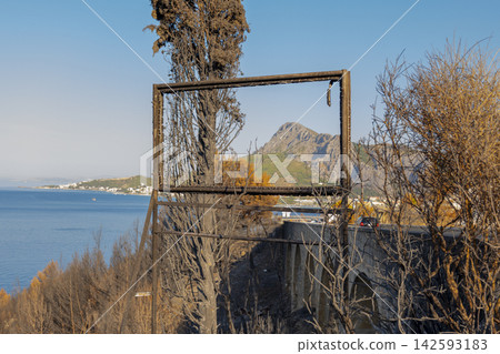Rusty empty frame overlooking Croatian coast and distant mountain landscape Rusty empty frame overlooking Croatian coast and distant mountain landscape 142593183