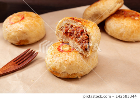crispy layered meat pie broken open to show juicy beef filling, traditional Asian street food. crispy layered meat pie broken open to show juicy beef filling, traditional Asian street food. 142593344
