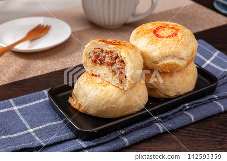 crispy layered meat pie broken open to show juicy beef filling, traditional Asian street food. 142593359