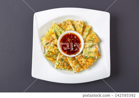 Chinese pan fried egg flatbread with chopped green chili peppers on green ceramic plate Chinese pan fried egg flatbread with chopped green chili peppers on green ceramic plate 142593392