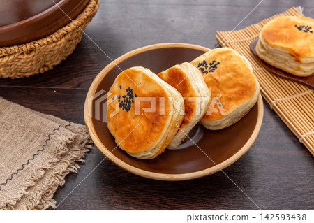 chinese multi-layered flatbread Qiancengbing, golden crispy flaky scallion pancake sprinkled with black sesame seeds. chinese multi-layered flatbread Qiancengbing, golden crispy flaky scallion pancake sprinkled with black sesame seeds. 142593438
