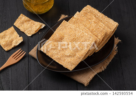 henan style crispy square sesame flatbread tile crackers on black ceramic plate henan style crispy square sesame flatbread tile crackers on black ceramic plate 142593554