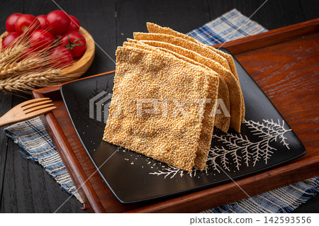 henan style crispy square sesame flatbread tile crackers on black ceramic plate henan style crispy square sesame flatbread tile crackers on black ceramic plate 142593556