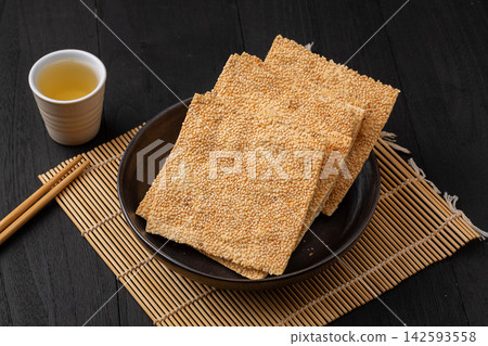 henan style crispy square sesame flatbread tile crackers on black ceramic plate henan style crispy square sesame flatbread tile crackers on black ceramic plate 142593558