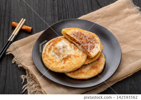 pan fried Chinese meat pies stuffed with black pepper beef filling on ceramic plate 142593562