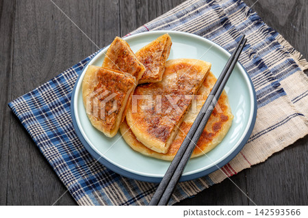 pan fried Chinese meat pies stuffed with black pepper beef filling on ceramic plate pan fried Chinese meat pies stuffed with black pepper beef filling on ceramic plate 142593566