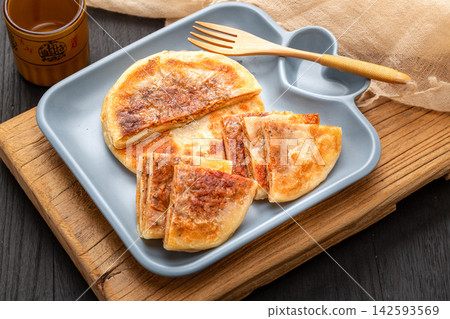 pan fried Chinese meat pies stuffed with black pepper beef filling on ceramic plate 142593569