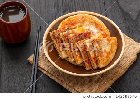 pan fried Chinese meat pies stuffed with black pepper beef filling on ceramic plate 142593570
