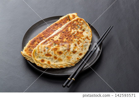 pan-fried Chinese chive and egg pies, traditional stuffed flatbread on a plate. pan-fried Chinese chive and egg pies, traditional stuffed flatbread on a plate. 142593571