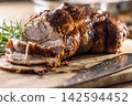 Tasty roasted pork neck with a crispy crust is garnished with fresh rosemary and sliced on a wooden board. This professional culinary shot will fit perfectly in cookbooks, restaurant menus, or food 142594452
