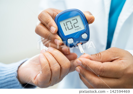 Doctor check diabetes from finger blood sugar level with finger lancet. 142594469