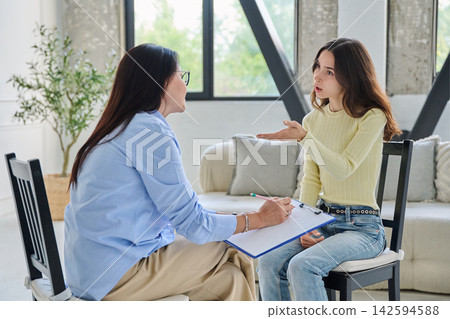 Young woman talking to female psychologist during therapy session Young woman talking to female psychologist during therapy session 142594588