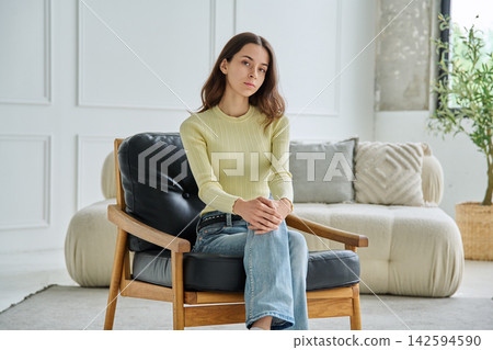 Portrait of 18 years old teenage girl sitting in armchair at home Portrait of 18 years old teenage girl sitting in armchair at home 142594590