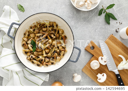 Mushroom cooking concept with sauteed champignons in pot and raw ingredients Mushroom cooking concept with sauteed champignons in pot and raw ingredients 142594695