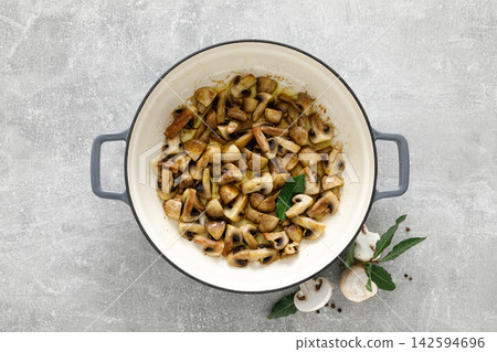 Mushroom cooking concept with sauteed champignons in pot and raw ingredients Mushroom cooking concept with sauteed champignons in pot and raw ingredients 142594696