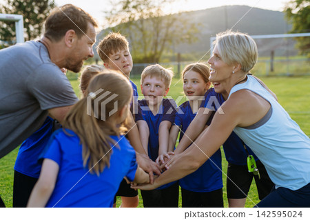 Young football players and coaches building team spirit before match. Young football players and coaches building team spirit before match. 142595024