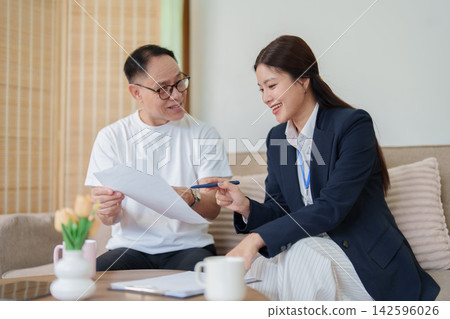 Financial advisor explaining contract terms to senior Asian man at home meeting Financial advisor explaining contract terms to senior Asian man at home meeting 142596026