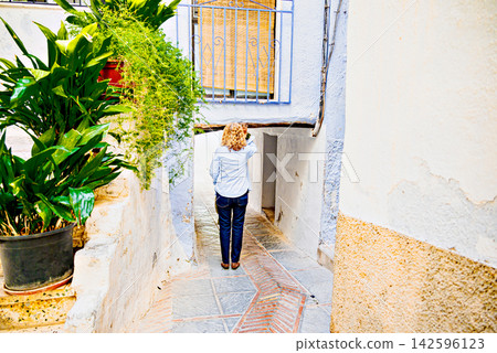 Blonde woman with curly hair, strolling through the streets of Lanjaron, Alpujarra region of Granada province Blonde woman with curly hair, strolling through the streets of Lanjaron, Alpujarra region of Granada province 142596123