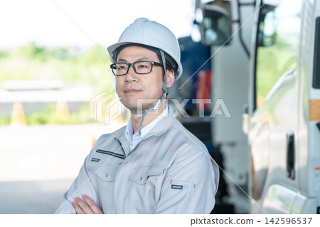 一位面帶微笑的現場工程師站在重型機械前。 一位面帶微笑的現場工程師站在重型機械前。 142596537