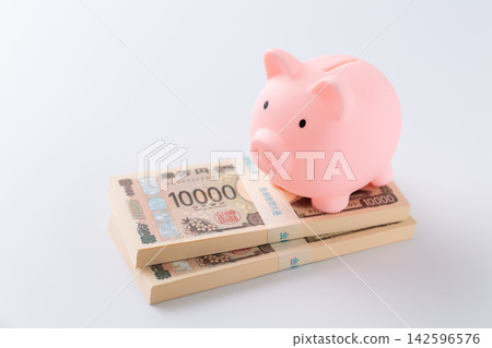 一疊200萬日元鈔票和一個粉紅色的小豬存錢罐 一疊200萬日元鈔票和一個粉紅色的小豬存錢罐 142596576