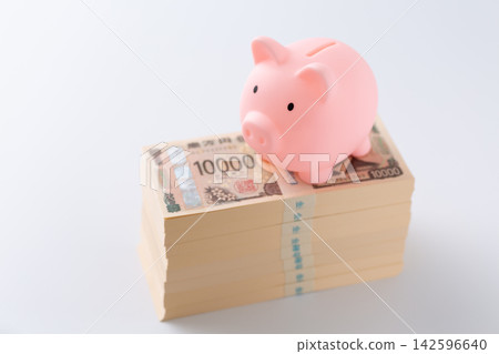 一疊800萬日元鈔票和一個粉紅色的小豬存錢罐 一疊800萬日元鈔票和一個粉紅色的小豬存錢罐 142596640