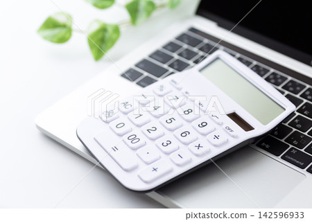 Laptop and white calculator Laptop and white calculator 142596933