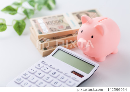 A stack of 3 million yen bills, a pink piggy bank, and a calculator. A stack of 3 million yen bills, a pink piggy bank, and a calculator. 142596934