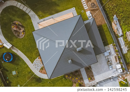 House with a gray metal roof. Corrugated metal roof and metal roofing. Modern roof made of metal. House with a gray metal roof. Corrugated metal roof and metal roofing. Modern roof made of metal. 142598245