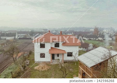 House with an orange metal roof. Corrugated metal roof and metal roofing. Modern roof made of metal. House with an orange metal roof. Corrugated metal roof and metal roofing. Modern roof made of metal. 142598268