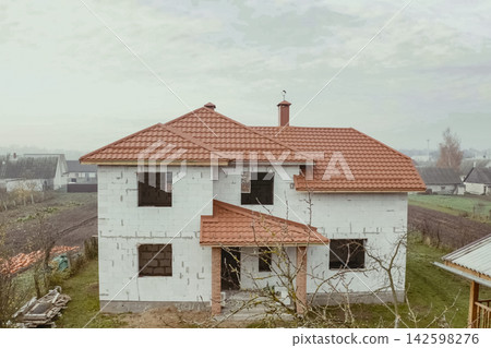House with an orange metal roof. Corrugated metal roof and metal roofing. Modern roof made of metal. House with an orange metal roof. Corrugated metal roof and metal roofing. Modern roof made of metal. 142598276