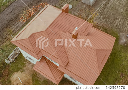 House with an orange metal roof. Corrugated metal roof and metal roofing. Modern roof made of metal. House with an orange metal roof. Corrugated metal roof and metal roofing. Modern roof made of metal. 142598278