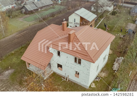 House with an orange metal roof. Corrugated metal roof and metal roofing. Modern roof made of metal. House with an orange metal roof. Corrugated metal roof and metal roofing. Modern roof made of metal. 142598281