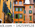 Terracotta and Yellow Buildings Facades with Wooden Shutters and Balconies in Verona Italy 142599528
