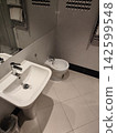 Modern Bathroom Interior with Ceramic Sink, Bidet, and Tiled Floor at home 142599548