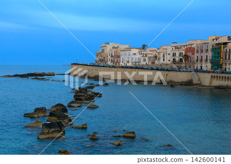Romantic European waterfront city skyline at dusk with historic stone buildings 142600141