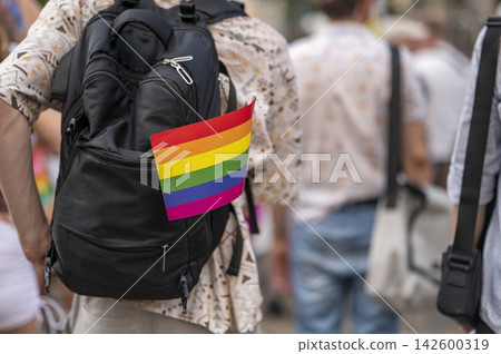 Rainbow Pride Flag Attached to Backpack at Outdoor Celebration Rainbow Pride Flag Attached to Backpack at Outdoor Celebration 142600319