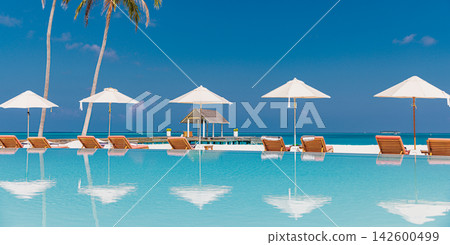 Inviting beach loungers thatched umbrellas powdery shore calm mirror azure lagoon blue sky tropical paradise. Perfect summer travel vacation island holiday. Exotic honeymoon getaway relax coast Inviting beach loungers thatched umbrellas powdery shore calm mirror azure lagoon blue sky tropical paradise. Perfect summer travel vacation island holiday. Exotic honeymoon getaway relax coast 142600499