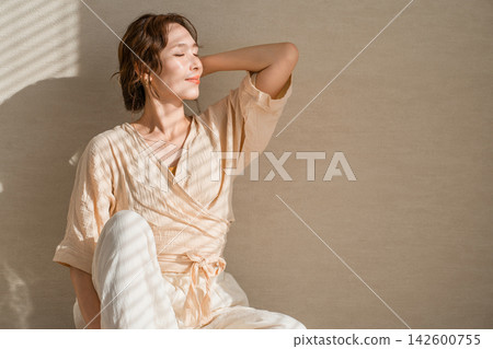 一位女士在陽光下放鬆身心。這種美麗的生活方式讓人聯想到防曬和紫外線防護。 一位女士在陽光下放鬆身心。這種美麗的生活方式讓人聯想到防曬和紫外線防護。 142600755