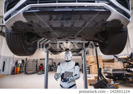 A humanoid robot with a tablet and wrench inspects the underside of a car on a lift in a workshop A humanoid robot with a tablet and wrench inspects the underside of a car on a lift in a workshop 142601124