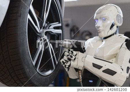 A humanoid robot uses a power tool to tighten the lug nuts on a car's wheel in a workshop setting A humanoid robot uses a power tool to tighten the lug nuts on a car's wheel in a workshop setting 142601200