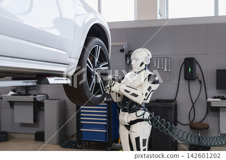 A humanoid robot uses a power tool to tighten a lug nut on a car wheel in a modern garage setting A humanoid robot uses a power tool to tighten a lug nut on a car wheel in a modern garage setting 142601202