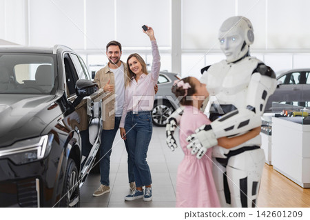 A smiling couple with car keys celebrates their new vehicle purchase while a child hugs a friendly robot in a modern dealership A smiling couple with car keys celebrates their new vehicle purchase while a child hugs a friendly robot in a modern dealership 142601209