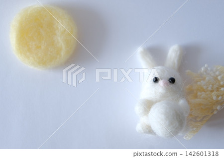 一隻羊毛氈白兔在滿月和蘆葦草的陪伴下欣賞月亮。 142601318