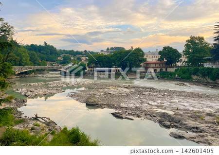Beautiful sunrise in Kutaisi. Rioni river bridge architecture and dawn sky with clouds Georgia Beautiful sunrise in Kutaisi. Rioni river bridge architecture and dawn sky with clouds Georgia 142601405