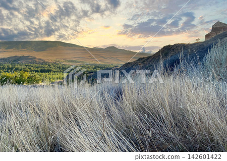 Sunset in the mountain. Wild dry grass and sky with cloud Sunset in the mountain. Wild dry grass and sky with cloud 142601422