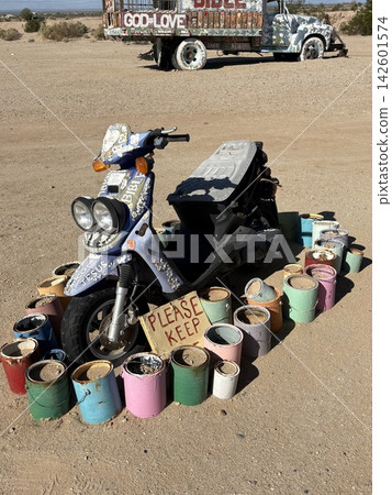 一輛被遺棄的摩托車,周圍散落著油漆罐。 一輛被遺棄的摩托車,周圍散落著油漆罐。 142601574
