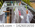White laundry drying on a clothesline on a residential building balcony 142601650