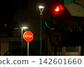 Night urban street scene with red traffic light, stop sign and street lamps 142601660