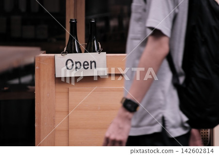 時尚餐廳的營業中標誌,以及路過男士的生活快照。 時尚餐廳的營業中標誌,以及路過男士的生活快照。 142602814
