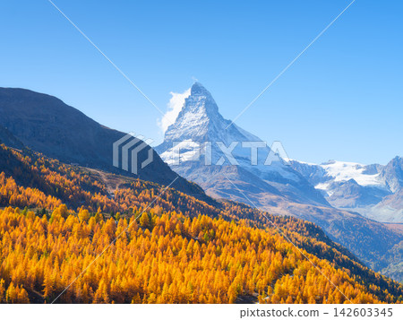 Matterhorn mountain peak rising above a colorful autumn forest in Zermatt, Switzerland. Matterhorn mountain peak rising above a colorful autumn forest in Zermatt, Switzerland. 142603345